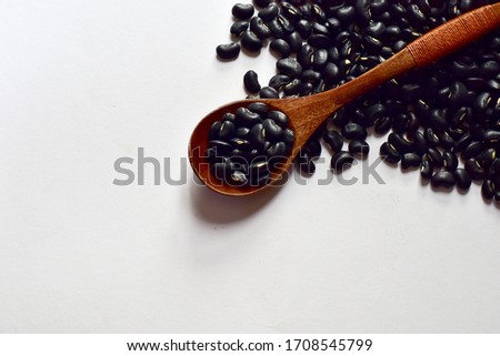 Top Views of Dried Black Beans in a wooden spoon isolated on the white background, Full depth of field.