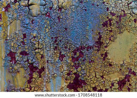 Textured multicoloured painted bubbly cracked rusty aged metal background.