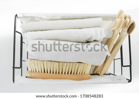 Eco natural body brush, wooden bamboo toothbrush and cotton face towels in metal basket. Zero waste concept. Bathroom essentials, plastic free items. Copy space, top view, flat lay