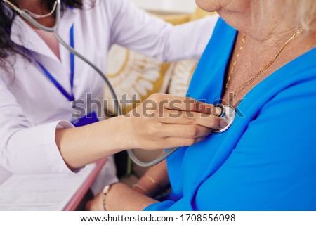 Close-up image of doctor using stethoscope to check heartbeat of senior woman Royalty-Free Stock Photo #1708556098