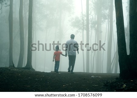 Father and Son Moving alone through mist. Father's day