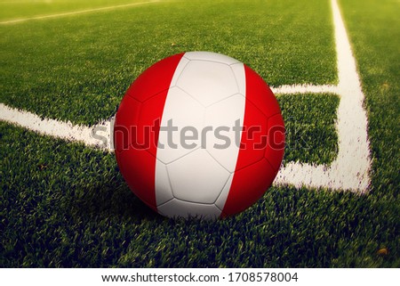 Peru flag on ball at corner kick position, soccer field background. National football theme on green grass.