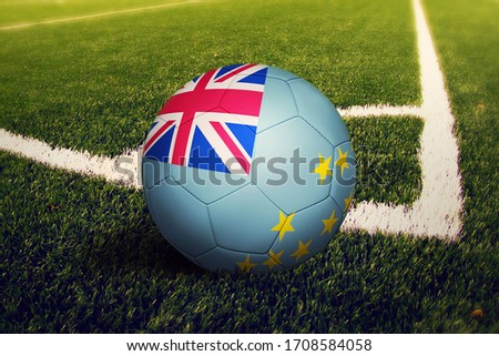 Tuvalu flag on ball at corner kick position, soccer field background. National football theme on green grass.