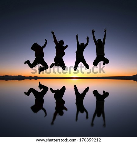 A group of happy young friends jumping in Solar de Uyuni, Bolivia