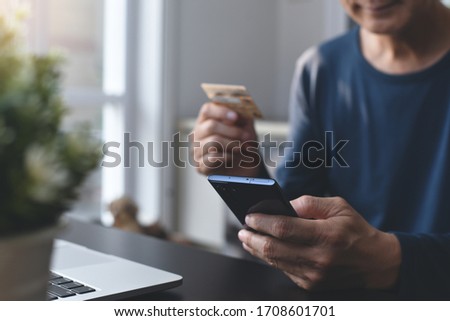 Digital banking, online shopping, internet payment, Ecommerce, financial technology concept. Man online shopping by credit card payment via mobile phone application and laptop computer at home