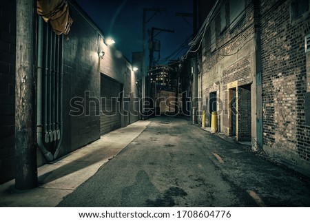 Dark and eerie urban city alley at night Royalty-Free Stock Photo #1708604776