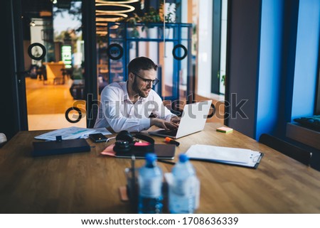 Caucasian male software developer sitting at coworking desktop with laptop technology and creating publication idea, millennial man using netbook for messaging and networking during freelance job