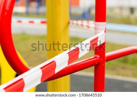 Barrage tape in the playground. Red-white striped ribbon. Stop line