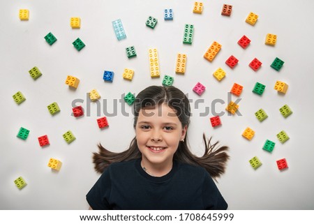 little girl with a constructor on a white background