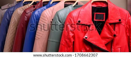 New collection of different color spring leather jackets for women. Colorful background of modern spring, autumn outerwear. Close up. Seasonal clothing in store on sale.