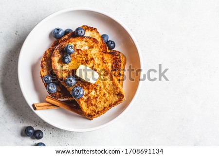 French toasts with blueberries and honey in a white plate. Royalty-Free Stock Photo #1708691134
