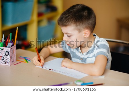 A school-age boy does homework at home. Training at school Royalty-Free Stock Photo #1708691155