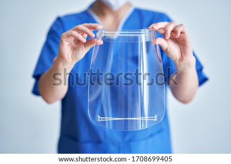 Portrait of female medical doctor wearing protective mask and face shield Royalty-Free Stock Photo #1708699405
