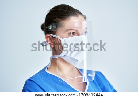 Portrait of female medical doctor wearing protective mask and face shield Royalty-Free Stock Photo #1708699444