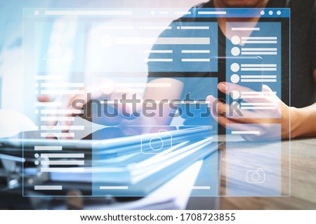 Web page browser of Social media Page VR Interface on the laptop computer.Designer hand using mobile payments online shopping and working from home.icons graphic interface. Royalty-Free Stock Photo #1708723855