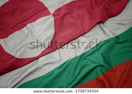 waving colorful flag of bulgaria and national flag of greenland. macro