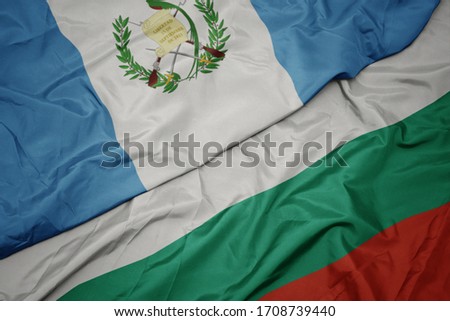 waving colorful flag of bulgaria and national flag of guatemala. macro