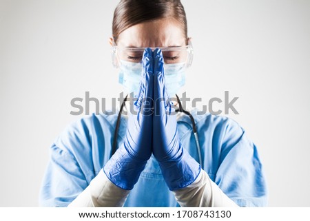 Female doctor praying hands gesture,hope and belief amid worldwide Coronavirus COVID-19 virus disease pandemic crisis outbreak,high global patient death toll and mortality rate with numerous victims Royalty-Free Stock Photo #1708743130