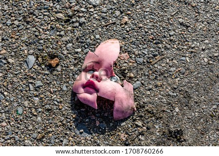 Scary broken doll face on the ground