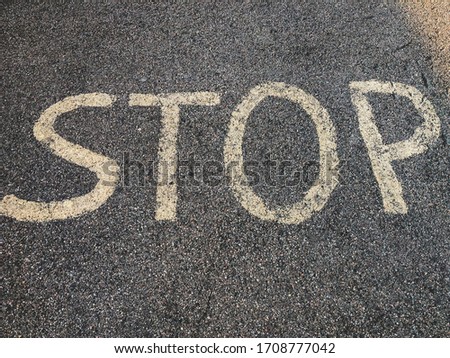 A stop sign painted on asphalt