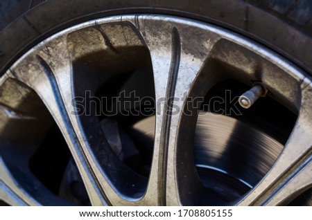 Alloy wheel with dirt and oil. A close-up of a road wheel covered with road dust and dirt. Return after traveling by car. Positive and adventure. Selective focus.