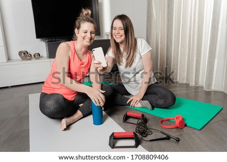 Two young girls talking on video call after playing sports at home.