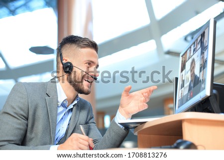 Businessman speak talk on video call with colleagues on online briefing during self isolation and quarantine. Webcam group conference with coworkers on laptop at office. Flu epidemic and covid-19. Royalty-Free Stock Photo #1708813276