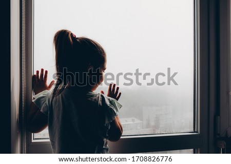 child looks out the window at smog in the city of Kiev. fog. air pollution is an environmental disaster. Kiev leader in air pollution in the  world            Royalty-Free Stock Photo #1708826776