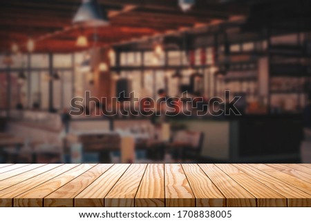 Empty wooden table with blurred restaurant background.