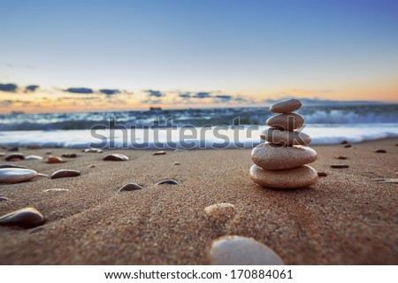 Stones balance on beach, sunrise shot  Royalty-Free Stock Photo #170884061