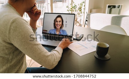 Woman teleconferencing with female colleague on laptop. Colleagues working from home having a video call and discussing work. Royalty-Free Stock Photo #1708844752