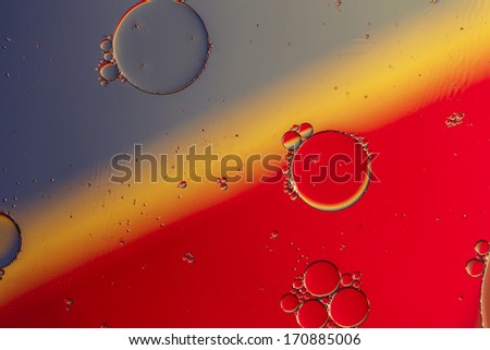 Oil drops on a water surface with color background