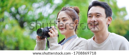 Asian couple going out with a camera