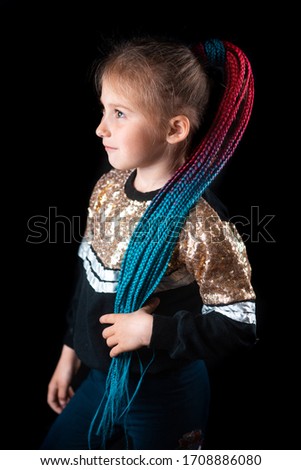 Little girl on a black background with turquoise and pink Afro elastic bands, pigtails tied in a ponytail cool