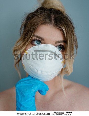 MERTHYR TYDFIL, WALES - 19 APRIL 2020 - Lady model shown wearing her personal protective equipment.  Face mask & surgical gloves during covid-19 epidemic.