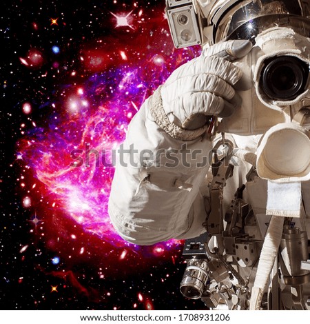 Astronaut and galaxy on the backdrop. The elements of this image furnished by NASA.
