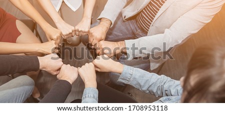 Creative team meeting fist bumps circle, hands together, asian people teamwork acquisition, brainstorm business people concept. Startup friends creative people sale project panoramic banner (blur) Royalty-Free Stock Photo #1708953118