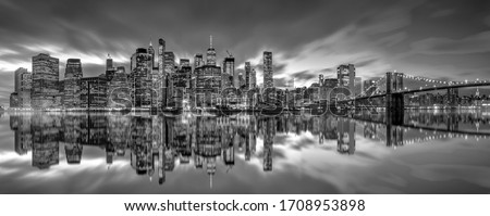 .New York City skyline with skyscrapers at sunset on Brooklyn Bridge black and white version