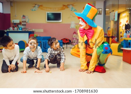 Clown animator play with group of little boys