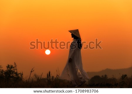 Vietnam girls with a Vietnamese traditional costume wearing Ao dai. Vietnam girls with sunset background