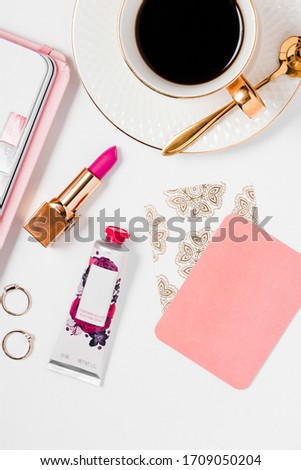 Pink and gold office details with a cup of coffee in a white background