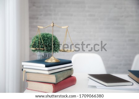 Gold brass balance scale on books in lawyer's office. Symbol of law and justice.