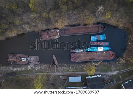 Beautiful cityscape with old rusty barges on the river at sunset. Eastern Europe. aerial photography