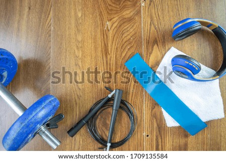 fitness composition with jump rope, dumbbell, earphones and resistance band