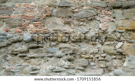 Natural stone wall texture. Medieval masonry. Ancient wall. Stone brick wall. Macro texture. Medieval architecture. Rough masonry. Background texture.
