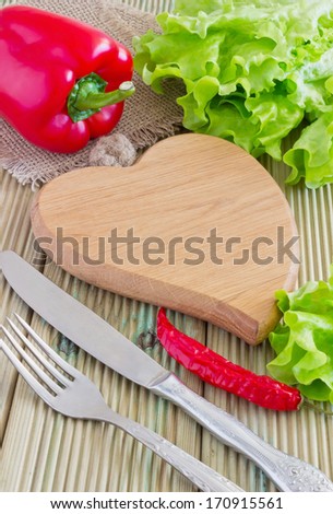 fresh and juicy lettuce and peppers next to the cutting board