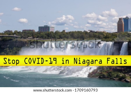 a futuristic font "stop covid-19" yellow banner over a blurred skyline of Niagara Falls USA