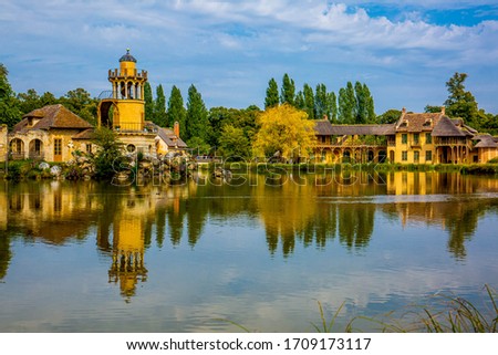 Landscape of the queen's hamlet, a place of Queen Marie-Antoinette inside the Trianon gardens in the Palace of Versailles, France. Royalty-Free Stock Photo #1709173117