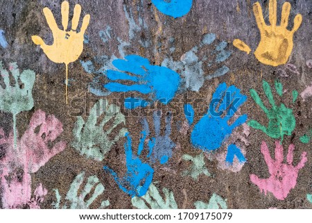 Dark background with colorful handprints symbolising interracial friendship Royalty-Free Stock Photo #1709175079