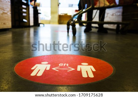Red circle symbol sign printed on ground at US supermarket cash register cue informing people to keep 6 feet distance from each other to prevent spreading Coronavirus COVID-19 virus disease infection Royalty-Free Stock Photo #1709175628
